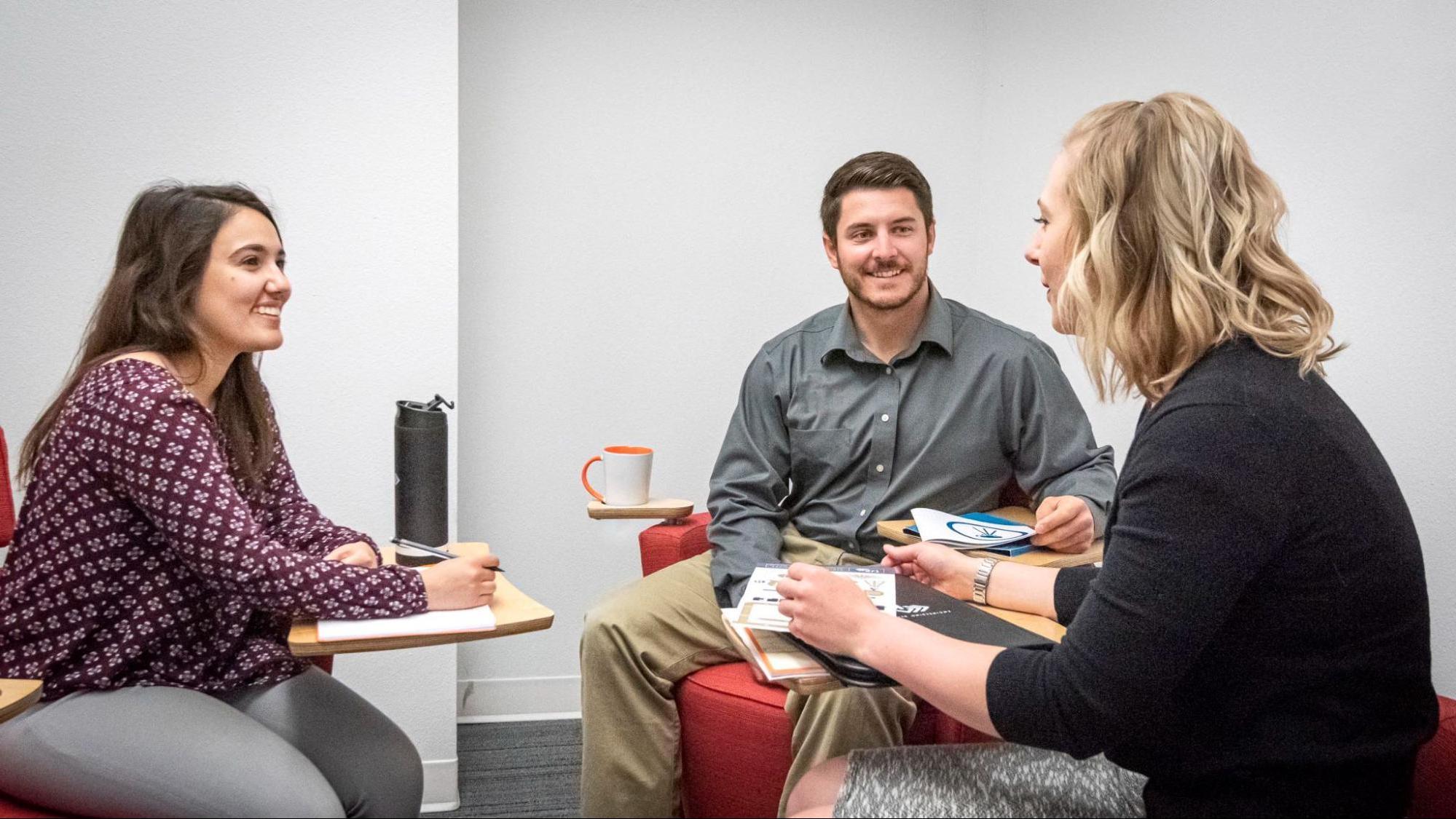 业务woman discussing marketing plans with two clients.